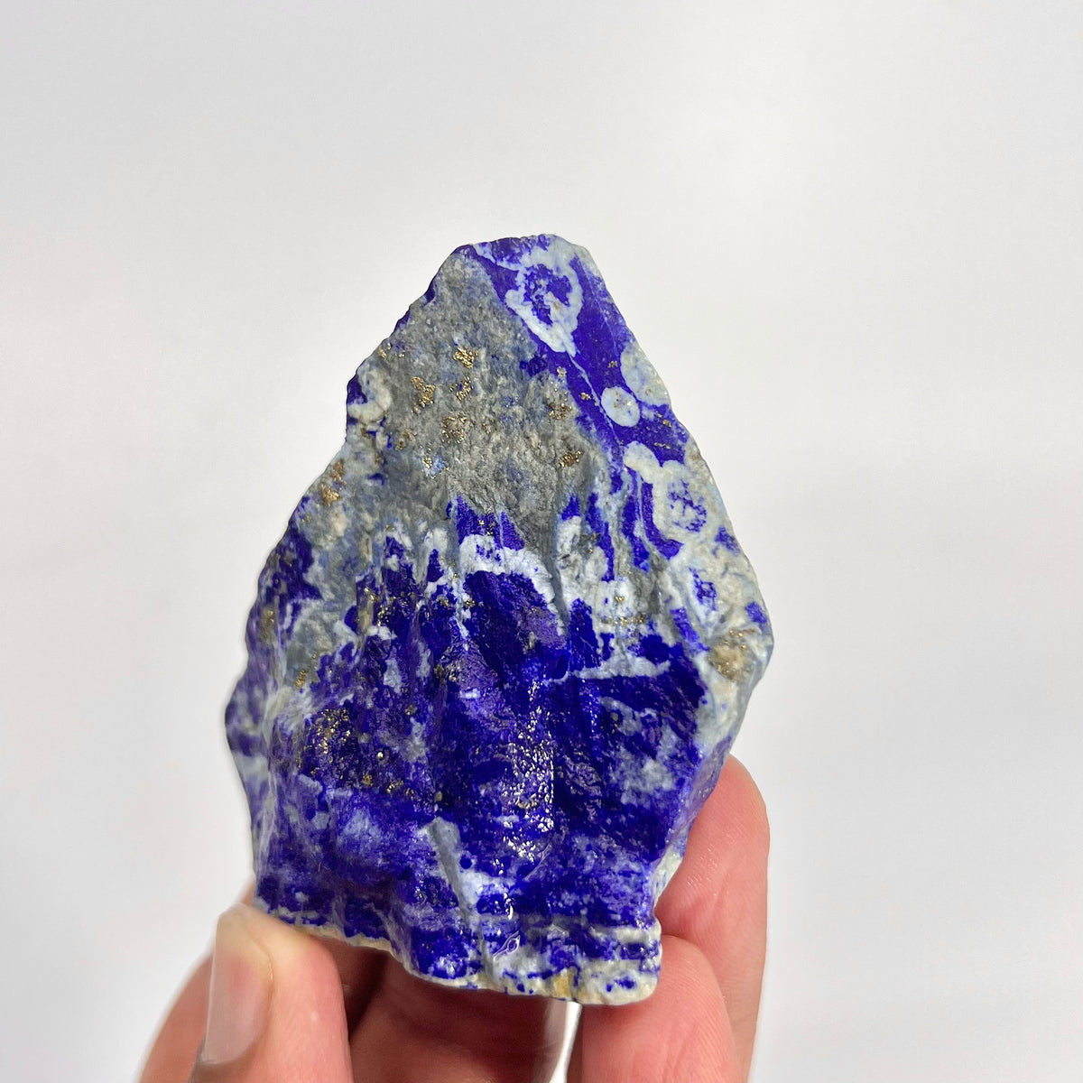 Detail shot of Lazurite blue coloring on rough specimen
Lapis Lazuli specimen displayed against neutral background
Lapis Lazuli rough stone, macro detail of matrix texture