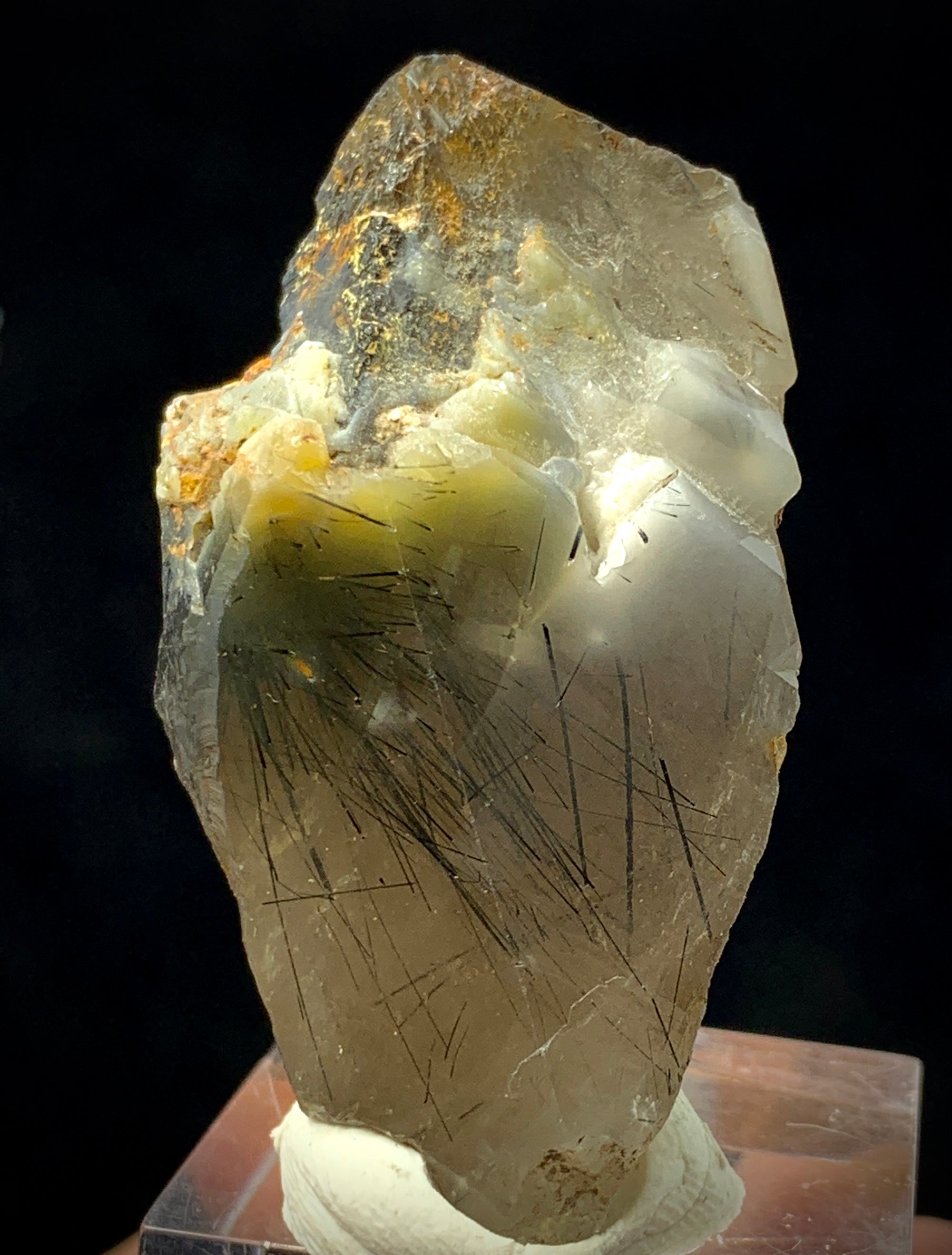 Crystal with visible fibers on a dark background