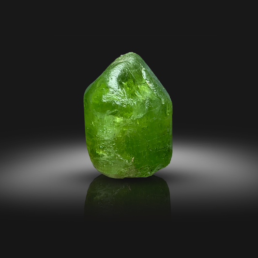 Green Peridot crystal from Front on a black background