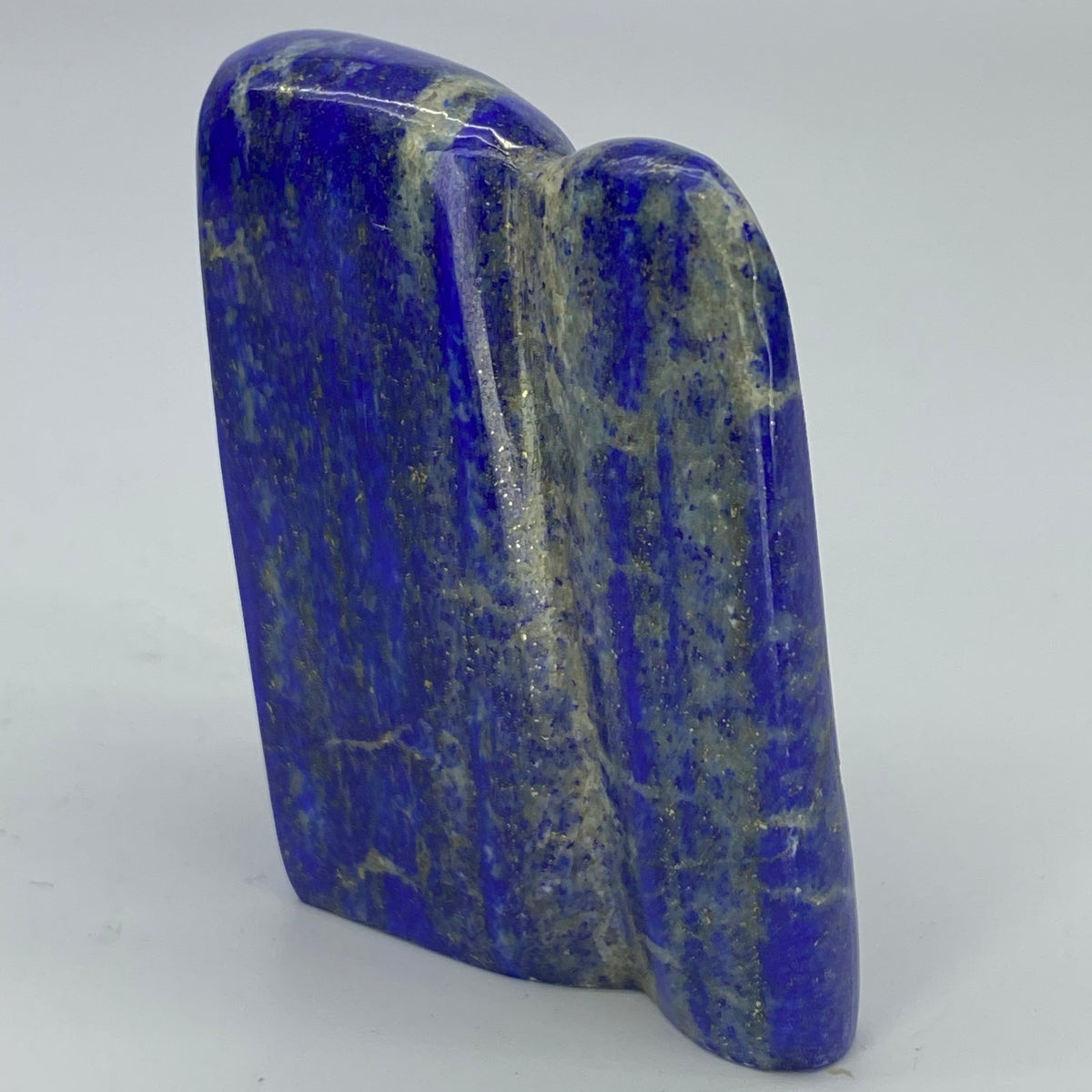 Back face of 132g Badakhshan Lapis Lazuli freeform
Small Lapis Lazuli freeform on a collector shelf