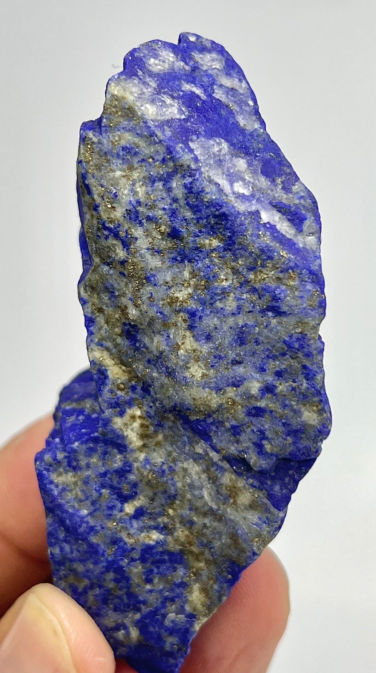 Deep indigo Lazurite surface with gold flecks
Top-down view of small blocky Lapis Lazuli